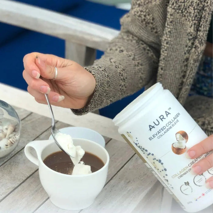 a spoonful of Aura Nutrition Elevated Collagen Creamer with MCT being added to coffee.